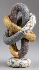 Obraz premium Intertwined, textured loops in grey, gold, and pink, sit atop a marble base