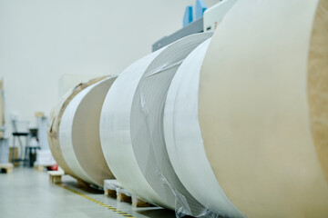 No people shot of huge rolls of paper in modern print shop storehouse, copy space