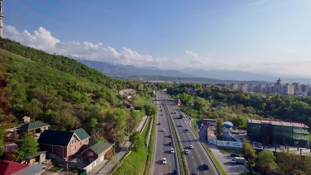 Almaty, Kazakhstan - April 25 2025: Point of view of the cable car that rides up the Kok Tobe hill over an highway in Almaty, Kazakhstan largest city on a sunny spring day. 