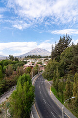 Blick von oben auf eine Straße, die durch Arequipas grüne Vororte führt, mit dem majestätischen...