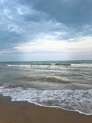 Peaceful Seashore with Gentle Waves under Cloudy Sky