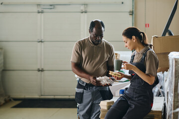Medium long shot of two ethnically diverse warehouse workers having lunch, copy space