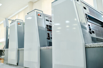 No people shot of modern offset printing press in print shop interior, copy space