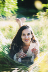 Beautiful model in a dress lies in the grass