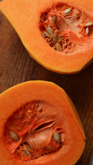 Fresh butternut squash halves with seeds on wooden cutting board slice pumpkin on a wooden...