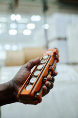 Close-up of hoist controller in hand of unrecognizable Black man, workday in warehouse concept