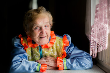A portrait of an elderly woman wearing traditional Slavic clothing, her expression calm and...