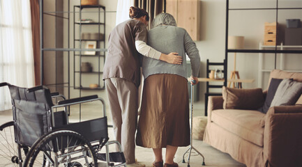 The nurse helps the elderly patient to walk