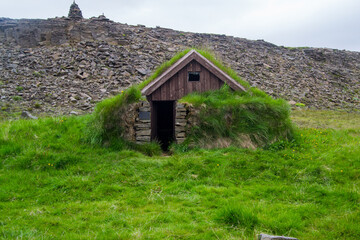 Traditional Icelandic architecture: a turf roof house in the Icelandic landscape.