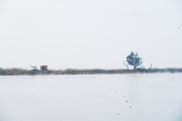 fishing houses inside the Po river Delta lagoon in an autumnal morning, Comacchio, Ferrara, Italy