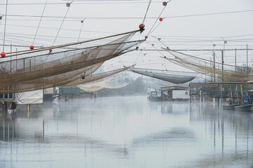 fishing houses inside the Po river Delta lagoon in an autumnal morning, Comacchio, Ferrara, Italy