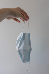 Woman’s hand holding medical face mask