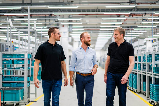Smiling businessman and employees in a factory