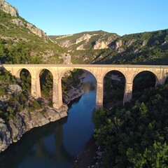 Mountain valley bridge over calm river