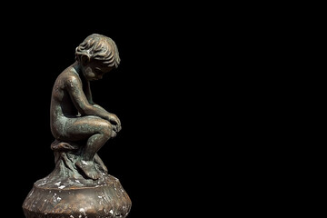 Statuette of a sad boy on a dark background