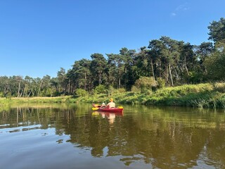 Kayaking adventure in the Nida Valley, surrounded by lush greenery and calm river waters. The photo...