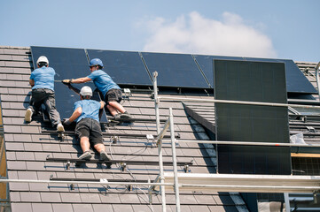 Engineers together installing solar panels on sunny day at rooftop