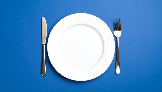 Empty White Plate, Knife, and Fork on Vibrant Blue Background
