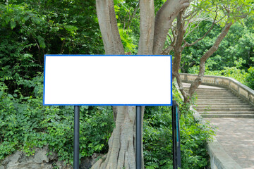 Front view of a advertisement blank board mockup at a green forest park.