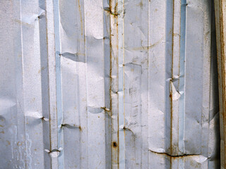 Old Corrugated Metal Sheet Fence with Rust and Dents.
