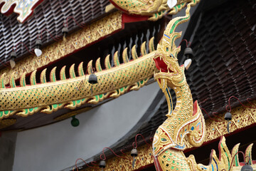 Obraz premium Chiang Mai, Thailand - July, 18, 2025 :Colorful ornate dragon sculpture on temple rooftop with intricate details in traditional Thai architectural style at Chiang Mai, Thailand.