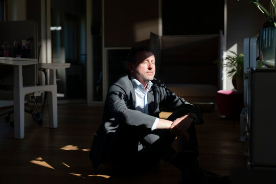 Businessman relaxing on office floor in daylight