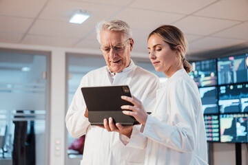 Medical professionals collaborating on tablet in modern clinic