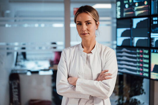 Confident doctor and researcher in modern clinic with medical data monitors