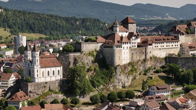 Aarburg castle in Switzerland, stunning close-up aerial view, rocky cliff with church and historic town views.