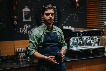 Barista standing with a professional demeanor, holding a jug, inside a cozy cafe setting with...