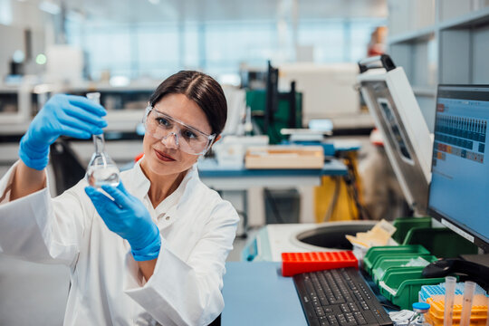 Scientist analyzing liquid sample in laboratory clean room