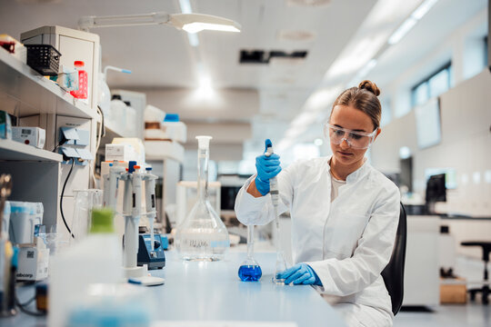 Scientist performing liquid analysis with pipette in modern laboratory