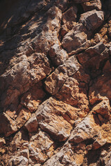 Exploring the textured beauty of ancient rock formations beneath the midday sun in a serene, natural landscape reminiscent of geological history
