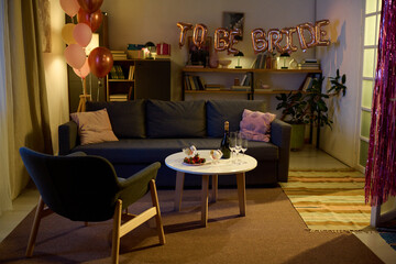 Living room decorated for bridal celebration with metallic balloons spelling TO BE BRIDE, pink and...