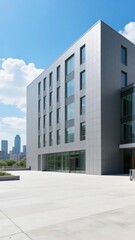 Modern multi-story building with large windows and a minimalist design against a clear sky.