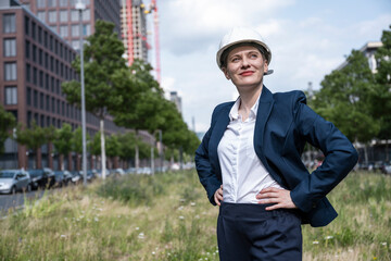 Engineer wearing construction helmet smiling outdoors in city