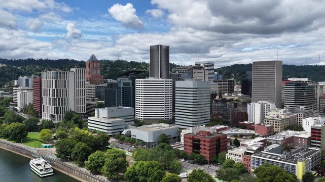 An aerial view of Portland, Oregon, reveals the city&rsquo;s skyline at the confluence of the Willamette and Columbia rivers, framed by lush greenery, distant mountains, and the charm of the Pac Northwest