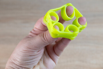 Green rubber hand grip tool used for developing hand strength and rehabilitation after injuries or...