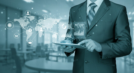 Businessman using tablet with world map and data visualization overlay in a modern office space