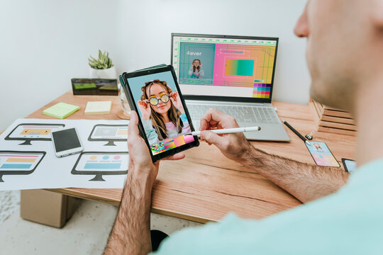 Web designer drawing on tablet PC at desk in office