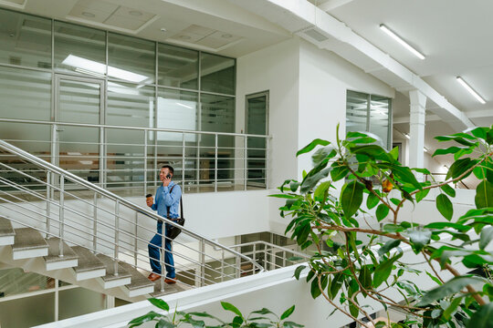 Businessman moving up stairs in modern green office