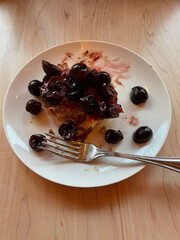 Cherry dessert slice with fork on plate.