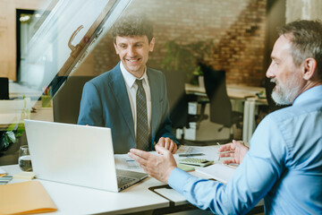 Business consultant meeting with client at desk in modern office