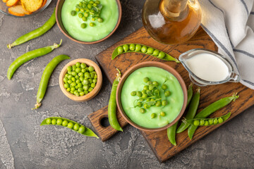 Green pea soup on a wooden table. Fresh pea soup bowl. Delicious healthy cream soup in a bowl with green peas and croutons. Healthy vegan puree. Copy space. Space for text.