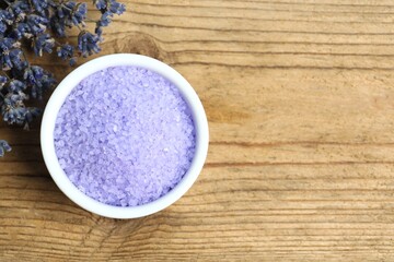 Lavender bath salt and lavender flowers on wooden background. Top view, space for text