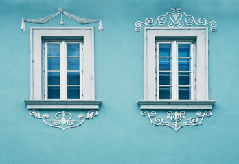 facade of Old vintage arched windows glowing with white curtains inside. Subotica Serbia Old Town,...