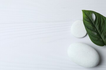 White background with stones and green leaf. Spa concept