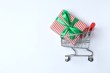 Shopping basket and gift box on white background. Black Friday or holiday shopping