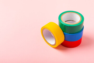 Insulating tape on a bright colored background. Set of different colors insulating tape. Reel...