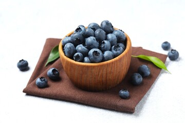 Fresh blueberries in a bowl on a gray table, close-up